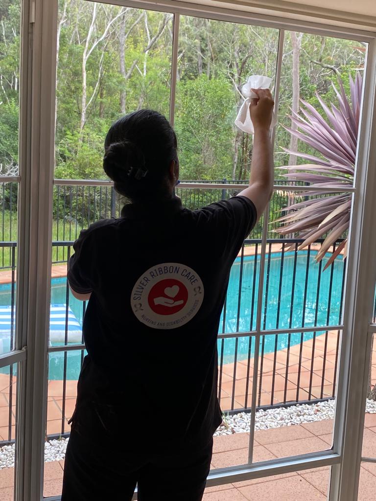 Professional Ndis cleaner wiping dinning mirror